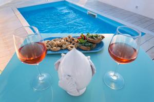 a table with two glasses of wine and a plate of food at Dimore Briganti Gallipoli Centro in Gallipoli