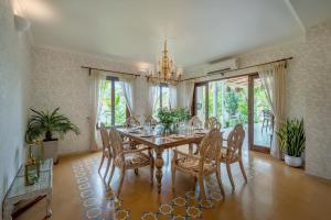 a dining room with a table and chairs at SaffronStays Sweet Mango - 4BR Goan Villa w Private Pool, Mango Garden, Bar Gazebo & Vibrant Interiors Near Beaches in Parra