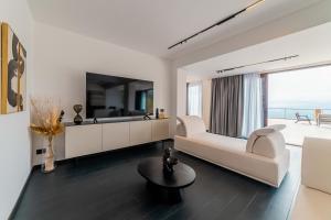 a white living room with a couch and a table at Dimora Eledia in Taormina