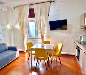 a living room with a table and yellow chairs at Suite sogni di lago Lecco, Como in Malgrate
