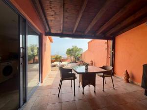 a dining room with a table and chairs on a patio at Montaña Blanca - Casa Bimba in Caleta De Fuste
