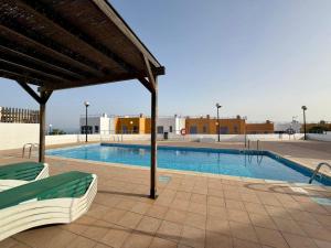 a swimming pool with two lounge chairs next to it at Montaña Blanca - Casa Bimba in Caleta De Fuste