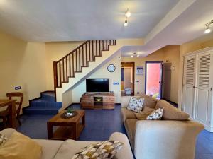 a living room with a couch and a staircase at Montaña Blanca - Casa Bimba in Caleta De Fuste