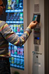 a man is using a drink machine in a store at Pension y Apartamentos Txingurri Experience in Astigarraga