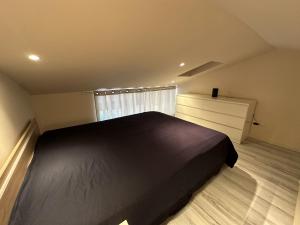 a bedroom with a black bed and a window at Cozy Duplex in Arles +24 photos