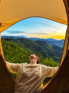 a person is looking out of a tent window at Glamping Tago in Khulo