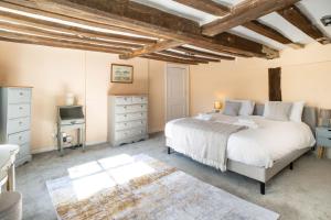 a bedroom with a large bed and a tv at Hill House Apartment in Framlingham