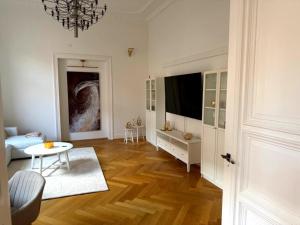 ein Wohnzimmer mit Fernseher und Tisch in der Unterkunft Apartment Stella in Kassel