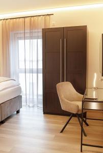 a bedroom with a bed and a chair and a table at Luxuriöse, 1-2-Zimmer-Apartments 30-55 qm in Fürstenau