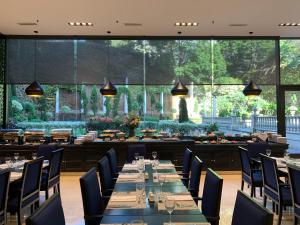 a dining room with tables and chairs and large windows at Emperador Hotel Buenos Aires in Buenos Aires