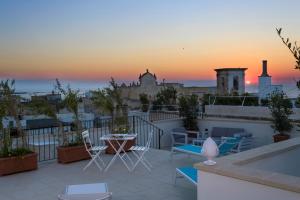 a balcony with chairs and a table and a sunset at Dimore Briganti Gallipoli Centro in Gallipoli