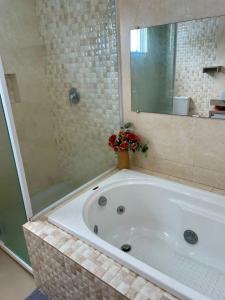 a bathroom with a large tub with a glass shower at Villa Serena Garden - Suíte com Hidromassagem - Ideal Casal in Cascavel +7 photos