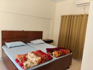 a bedroom with a bed with two pillows on it at Sai Devine Abode Of SAI at Sri Sathya Sai ghaat in Rishīkesh