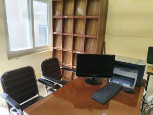 an office with a desk with a computer and two chairs at Sai Devine Abode Of SAI at Sri Sathya Sai ghaat in Rishīkesh
