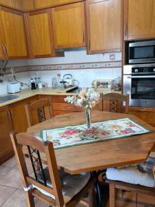 a kitchen with a wooden table with a vase of flowers on it at Casa do Limoeiro - Casa in Golegã +5 photos