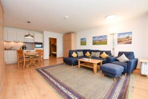 a living room with a blue couch and a table at Haus "Panorama" Appartement PAN019 in Duhnen