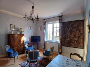 a living room with a table and chairs and a window at Mer et Style au coeur de l'éventail 3 pièces 2 chambres in Cabourg