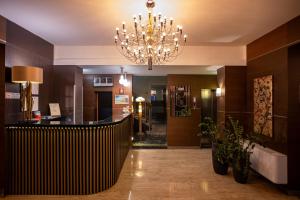 a lobby with a staircase and a chandelier at Hotel Vittoria in Trapani