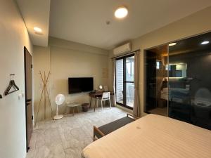 a room with a bed and a living room with a television at 熊熊&妮妮 in Dongshan