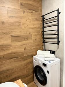 a washer and dryer in a bathroom with wooden walls at Apartment in Irpin Pavlenka in Irpin