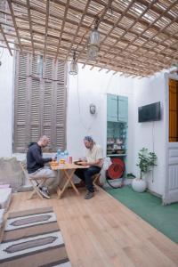 two men sitting at a table in a room at Rhala Hostel Egypt in Cairo