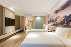 a hotel room with two beds and a flat screen tv at Atour Hotel Maqun Nanjing in Nanjing