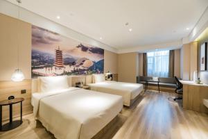 a hotel room with two beds and a desk at Atour Hotel Maqun Nanjing in Nanjing