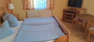 a bedroom with a bed with a blue and white blanket at Zur Schleibrücke in Boren +5 photos