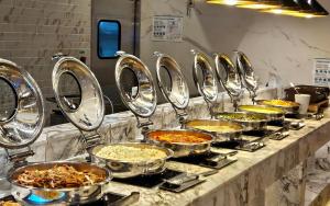 a buffet line of prepared food in metal pans at SainTree Hotel in Incheon