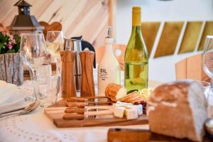 a table with a bottle of wine and bread and wine glasses at Tatra Góral Ski Apartament in Murzasichle