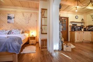 a bedroom with a bed and a wooden wall at Tatra Góral Ski Apartament in Murzasichle