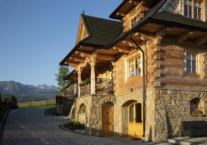 an old stone building with a black roof at Tatra Góral Ski Apartament in Murzasichle