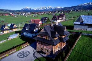 an aerial view of a house with mountains in the background at Tatra Góral Ski Apartament in Murzasichle