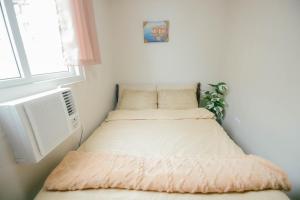 two beds in a small room with a window at M&B Urban Haven in Suba +50 photos