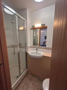a bathroom with a sink and a shower and a toilet at Castle Sleeper in Corby