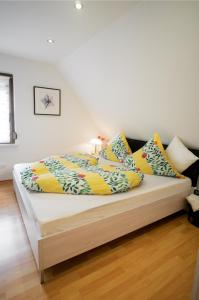 Bett mit bunten Kissen auf einem Zimmer in der Unterkunft Moseltraum-Fewo mit Klimaanlage-Burgblick und Balkon in Bernkastel-Kues