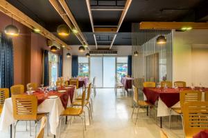 a dining room with tables and chairs with red and white tablecloths at Resort Atlantis in Dhalpur