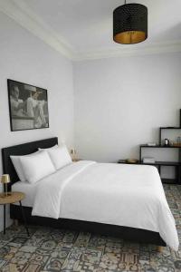 a white bedroom with a large bed and a table at KVS concept Écommoy chambres haut de gamme proche circuit 24 heures Le Mans in Écommoy