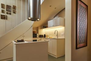 a kitchen with white cabinets and a staircase at Vava Residence in Heraklio