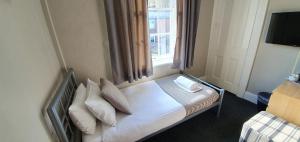 a bedroom with a bed with pillows and a window at The Grapes in Southampton
