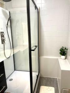 a shower with a glass door in a bathroom at L'échappée Jurassienne - Tout équipé au calme in Saint-Claude