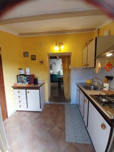 a kitchen with yellow walls and white cabinets at Casa Carini in Scansano
