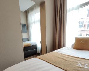a small room with a bed and a window at XO Hotel Inner in Amsterdam