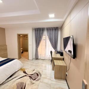 a bedroom with a bed and a desk and a television at Star Wish Business Hotel in Lagos
