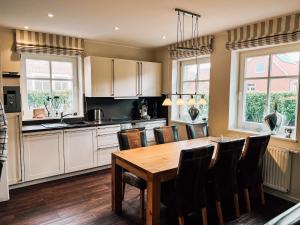 a kitchen with a wooden table and chairs at Feriendorf Marienhof C2 Marieke in Borkum +21 photos