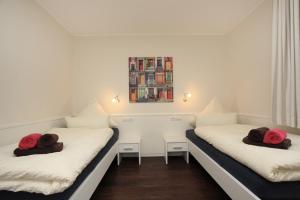 two beds in a room with red towels on them at Feriendorf Marienhof C2 Marieke in Borkum