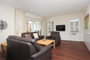 a living room with two couches and a table at Feriendorf Marienhof C2 Marieke in Borkum