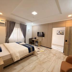 a bedroom with a bed and a desk and a television at Star Wish Business Hotel in Lagos