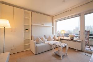a living room with a white couch and a table at Deichblick in List