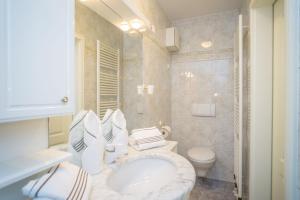 a bathroom with a white sink and a toilet at Am Austernstrand in List